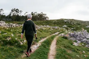 Woman walking through nature with soft sunlight, symbolizing reflection, healing, and the ongoing journey of soul-aligned living.