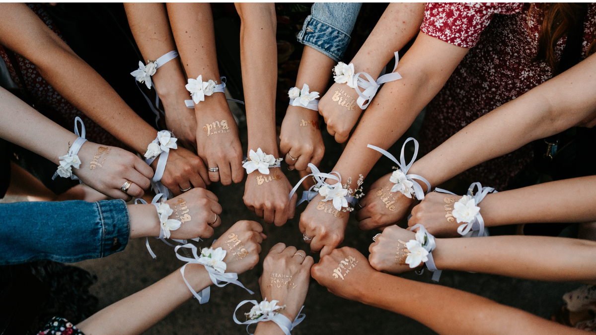 Erika Verhoeven Wisdom Awakening Circle of diverse women's forearms and hands joining in a unified fist bump, symbolizing strength, solidarity, and feminine power.